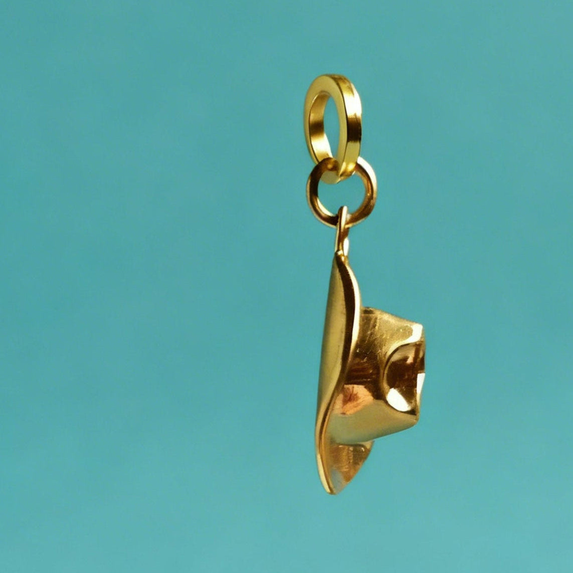 Gold pendant on a teal background